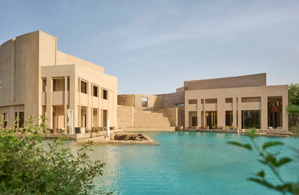 Low sand-coloured pavilions of Zulal Wellness Resort among gardens